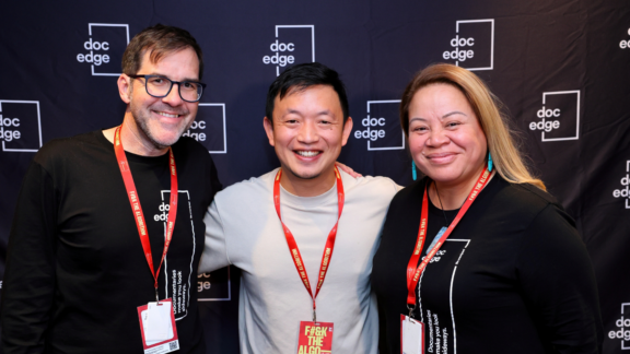 Filmmaker Daniel Lin stands before Doc Edge Film Festival backdrop