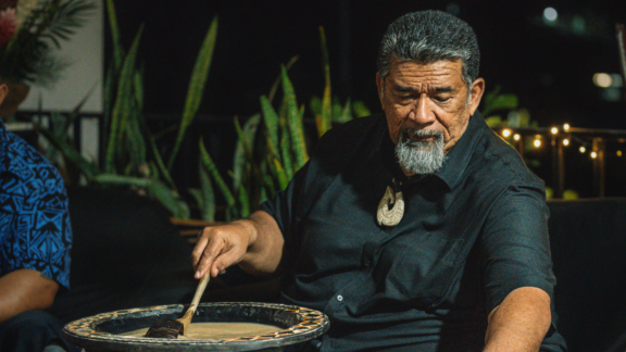 A man with a dark shirt focused on preparing a traditional ceremony outdoors