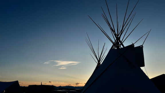 Silhouette of teepees at sunset